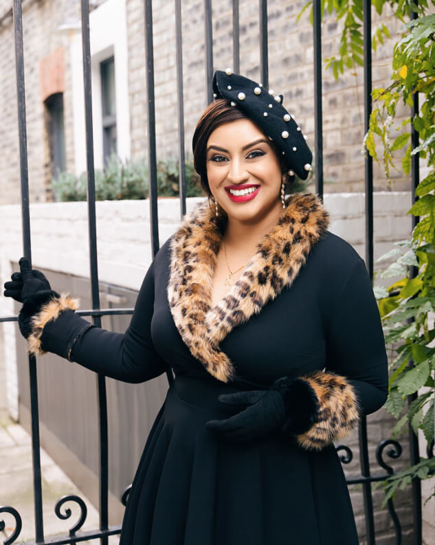 Spiritual Coach standing by gate with fur coat on